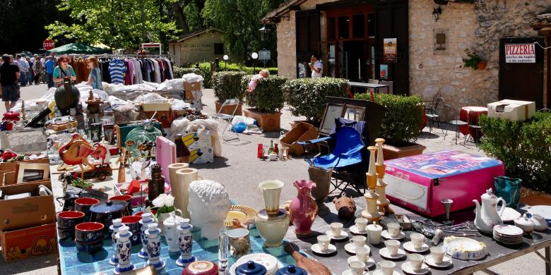 Immagine: Stalls of an antique market with ceramics, vintage items and clothes displayed outdoors near the Fonti del Clitunno 